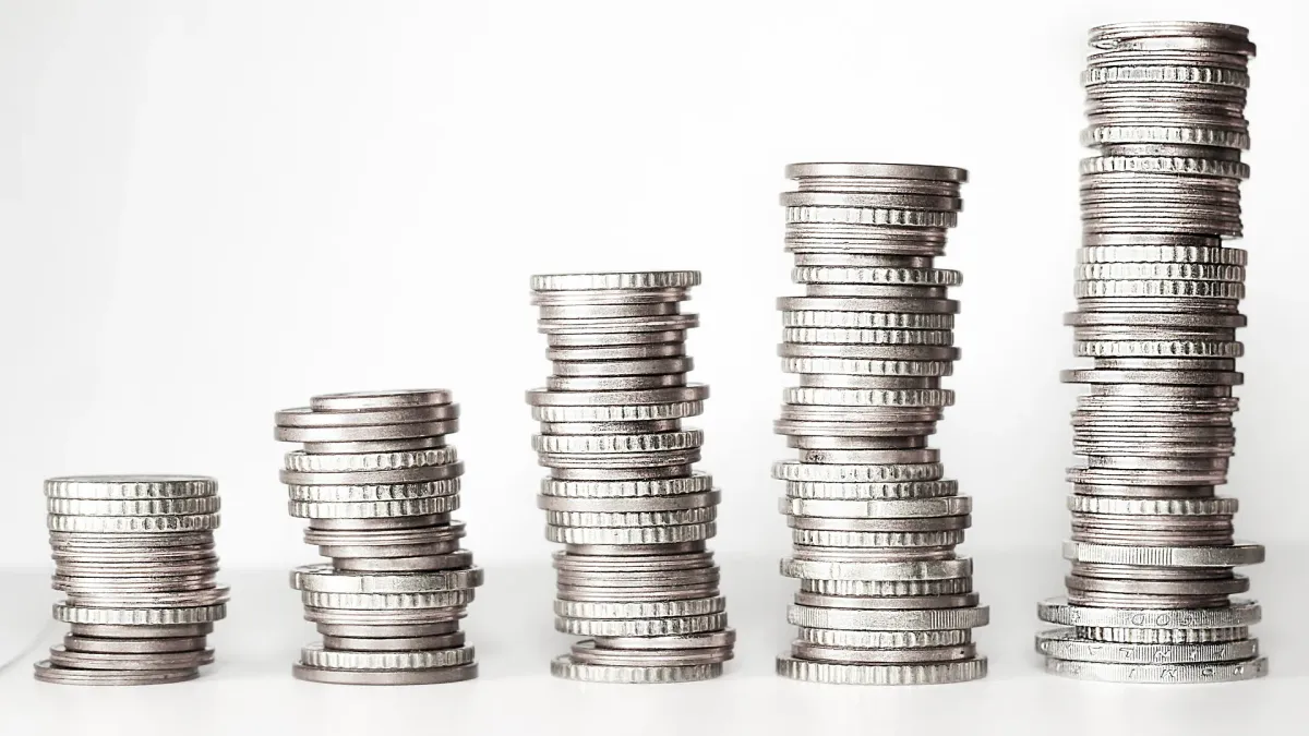 Five stacks of silver coins rising from short to tall